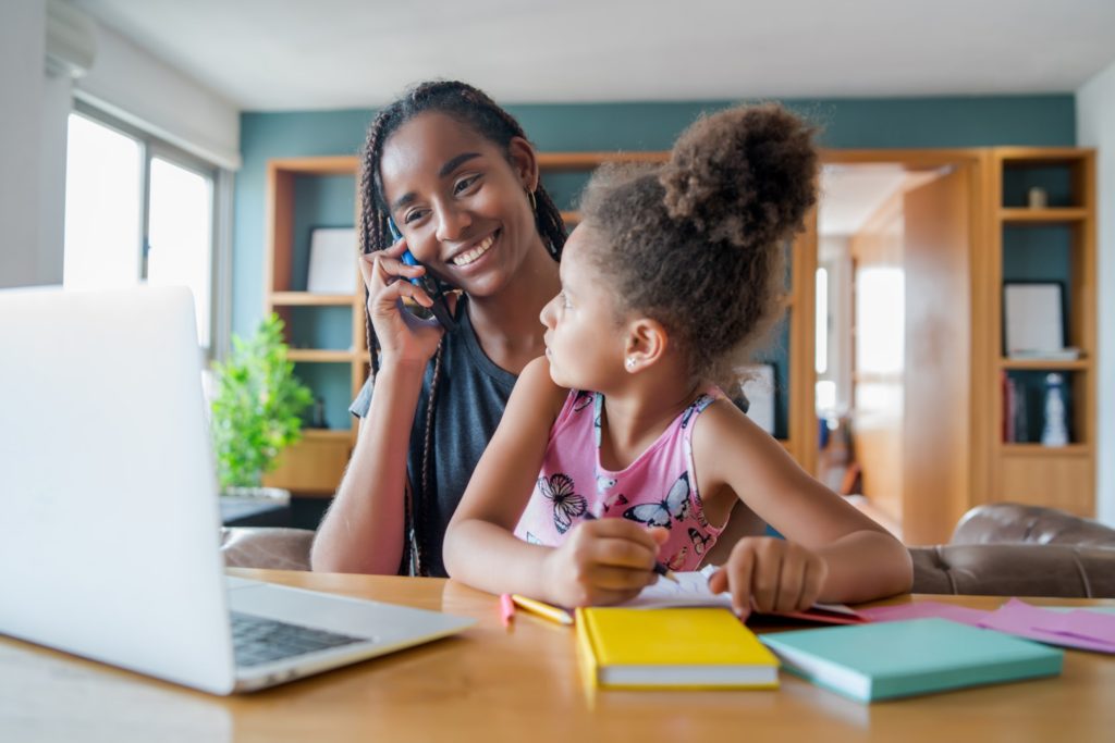 A mother helping her daughter with homeschool.